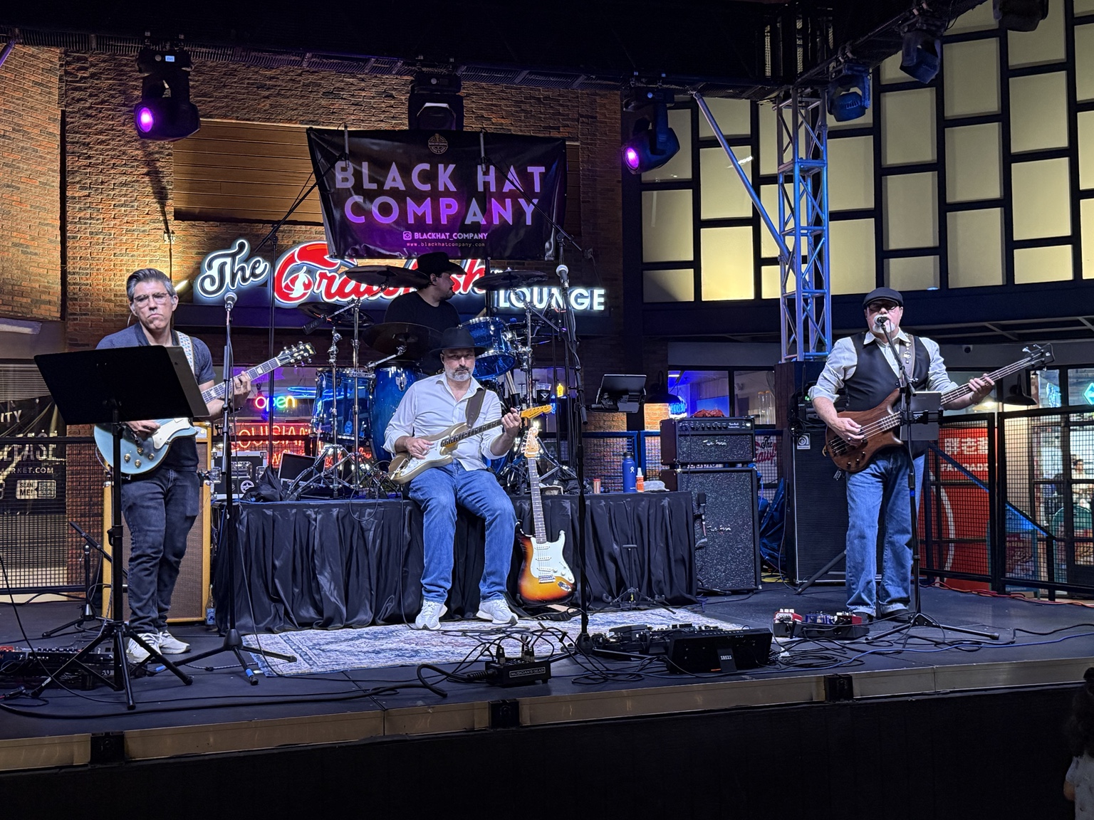 Black Hat Company performing together on a club stage